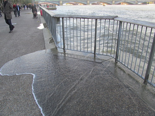 Waves break over Thames Path at Bankside after flood alert issued