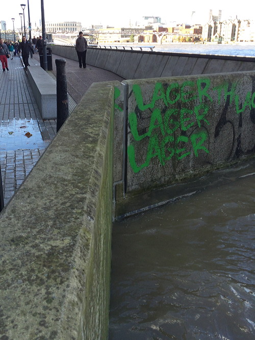 Waves break over Thames Path at Bankside after flood alert issued